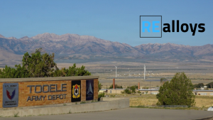 Sign reads 'TOOLE ARMY DEPOT' with U.S. Army Materiel Command badge; desert landscape and mountains in the background, and a blue REalloys logo in the sky.