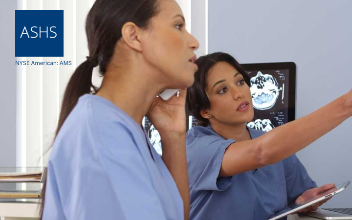 Two female healthcare workers in blue scrubs review medical images on a monitor, with the ASHS logo visible in the corner.